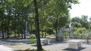 A park with a basketball court, benches, and trees. - Siblu 4* Capbreton 3-Bedroom Solar-Powered Mobile Home — Available (Capbreton)
