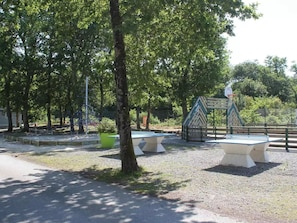 Ein Park mit Basketballplatz, Bänken und Bäumen.