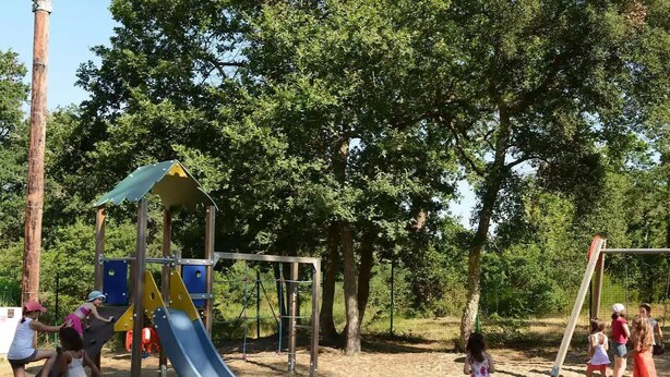 A playground with a slide and climbing structures, surrounded by trees. - Siblu 4* Capbreton 3-Bedroom Solar-Powered Mobile Home — Available (Capbreton)