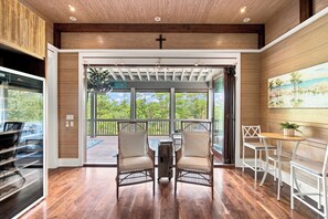 A spacious room with a wooden ceiling, a large window overlooking a deck, and a cross on the wall. - New Rental, WaterColor, Golf Cart, Resort Amenities (Santa Rosa Beach)