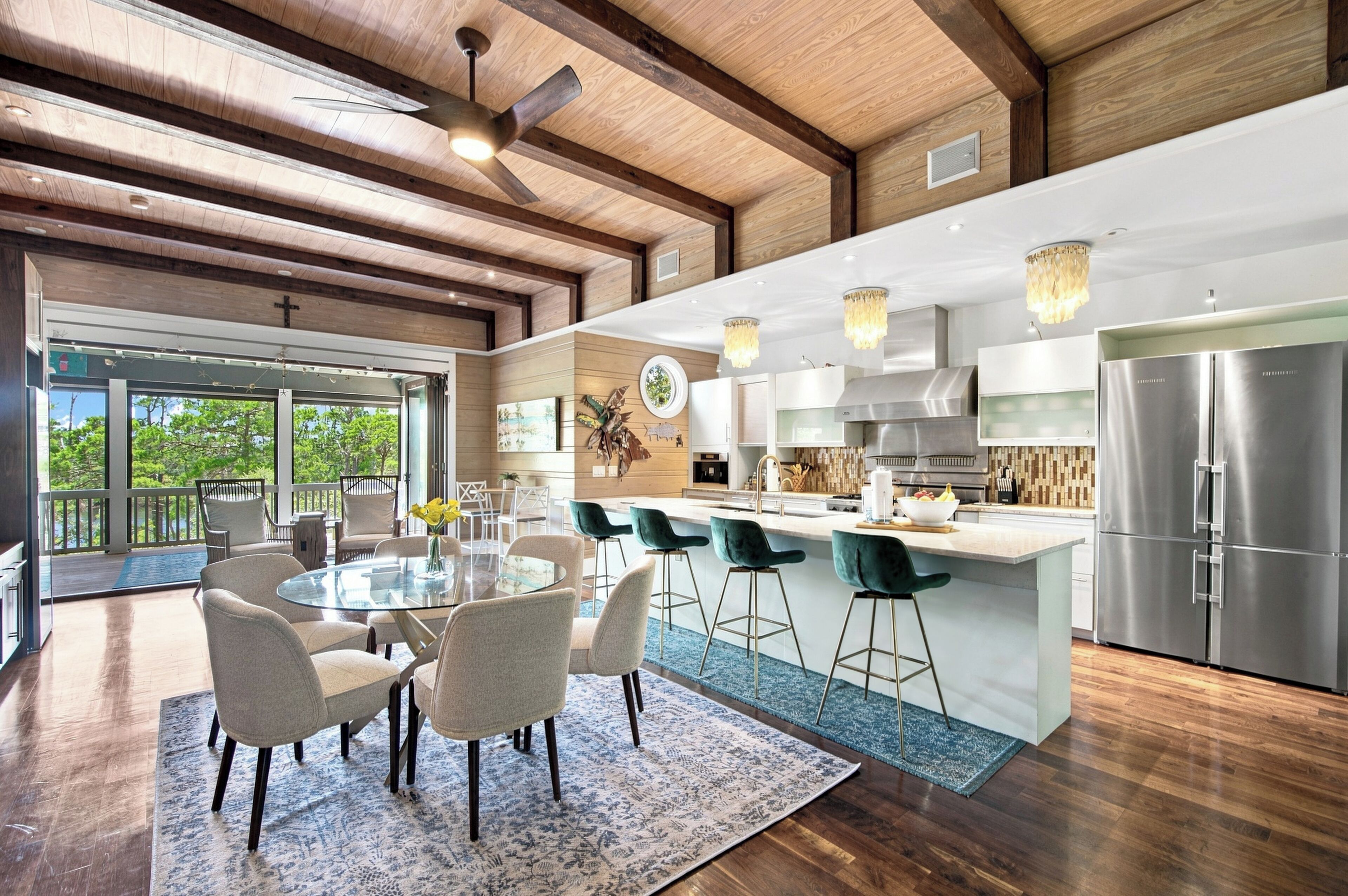 A modern kitchen with a large island, bar stools, and stainless steel appliances.