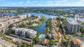 A high-rise hotel with multiple floors, a swimming pool, and a marina with boats. - Midnight Cove II 423F (Siesta Key)
