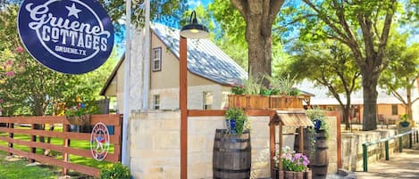 A rustic outdoor setting with a sign for 'Gruene Cottages' and a welcoming sign.