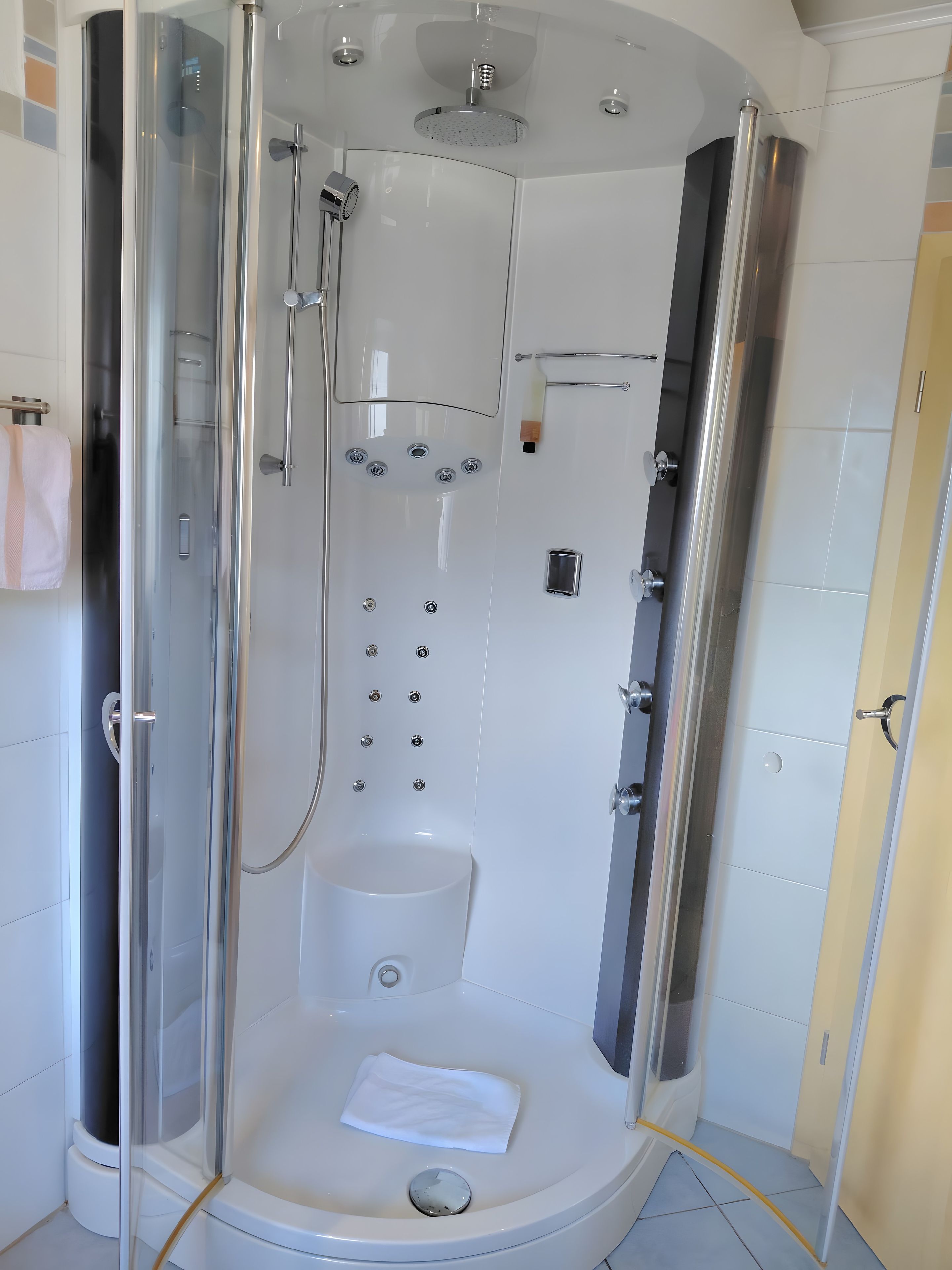 Un bagno moderno con doccia vetro, toilette e portasciugamani.
