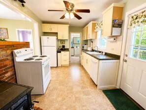 A kitchen with a stove, refrigerator, and cabinets.
