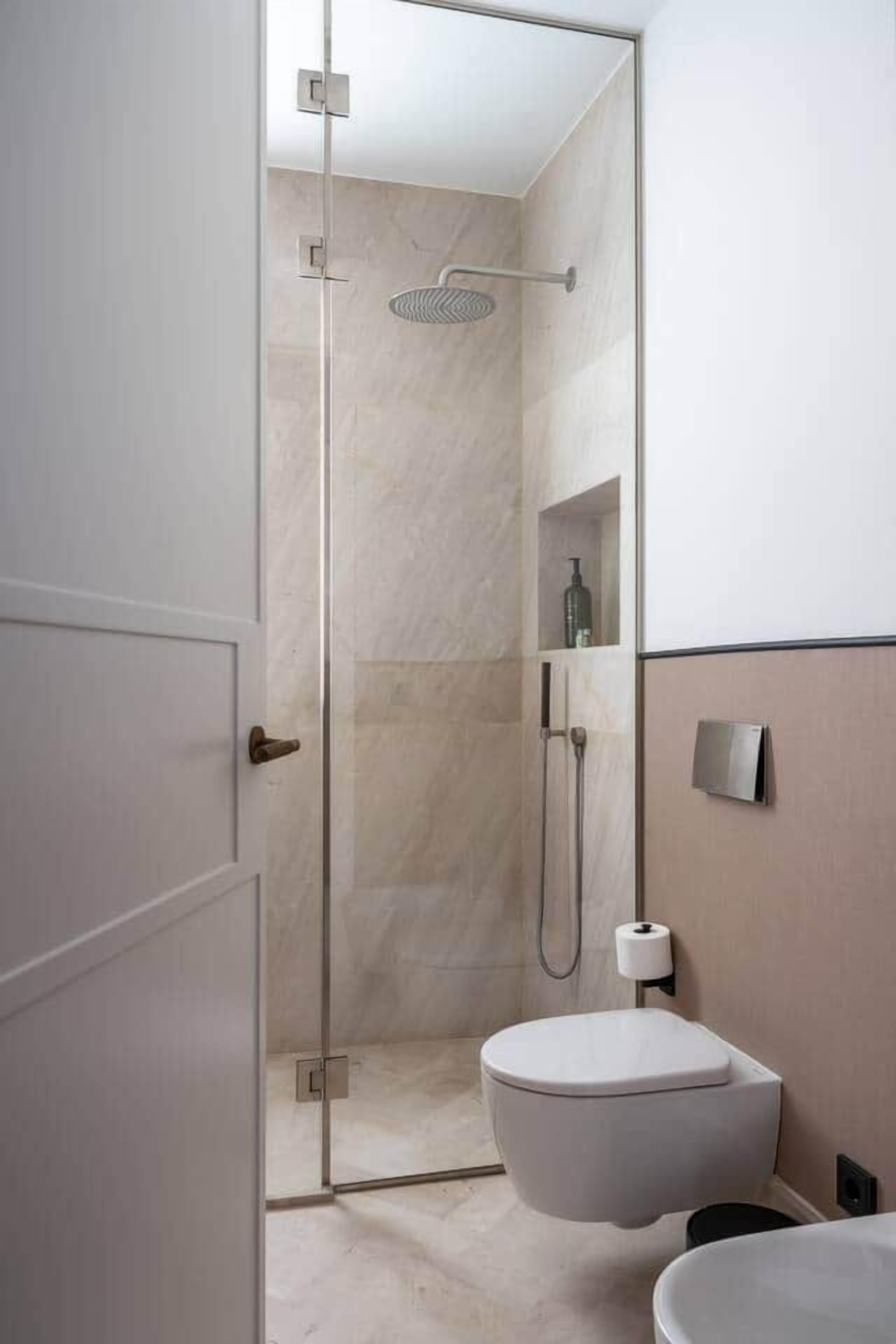 Une salle de bain moderne avec une douche à parois de verre, des toilettes et un lavabo.