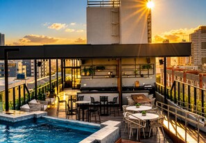A rooftop bar with a pool, outdoor seating, and city views. - Breeze Residence 401 Beachfront Flat at Bessa (João Pessoa)