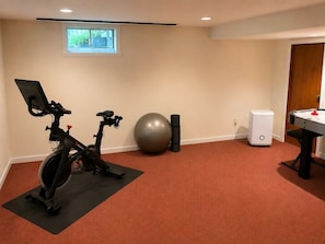 A room with two stationary bikes, a large exercise ball, and a foosball table. - The Woodland Retreat (Essex Junction)