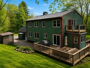 A two-story house with a deck, a barbecue area, and a small shed. - The Woodland Retreat (Essex Junction)