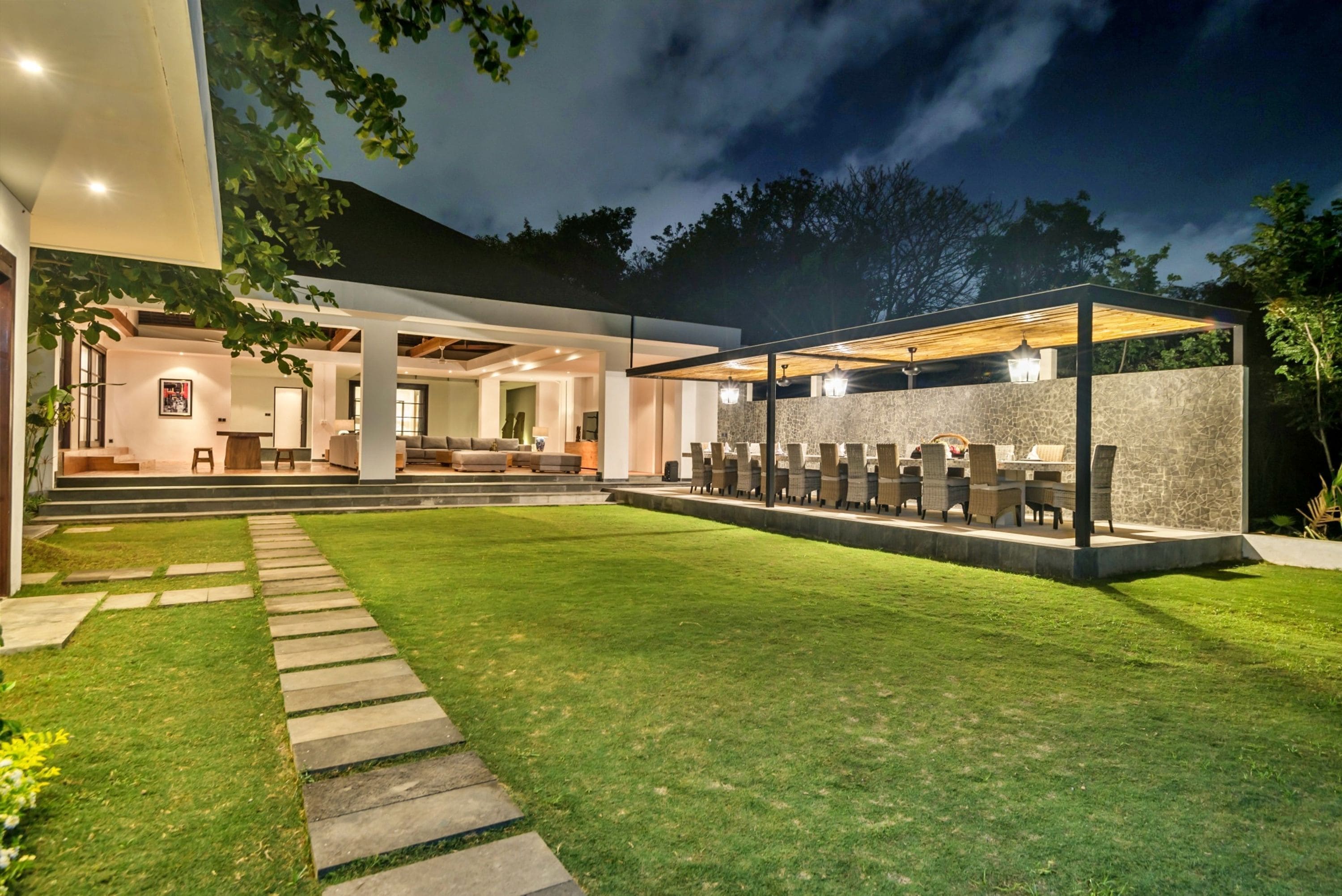 A modern outdoor seating area with a stone wall and multiple chairs.