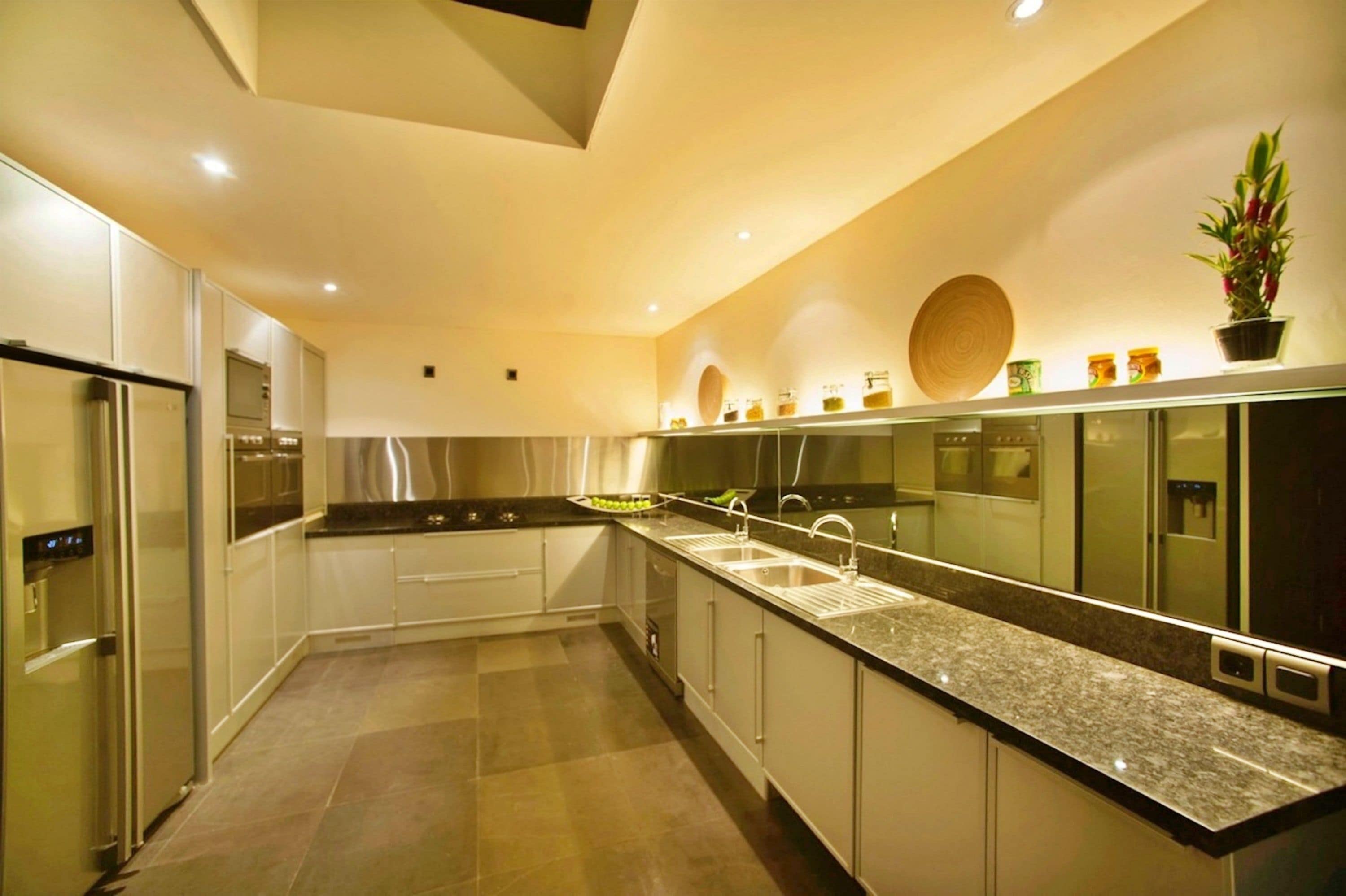 A modern kitchen with stainless steel appliances, a granite countertop, and a backsplash with decorative elements.
