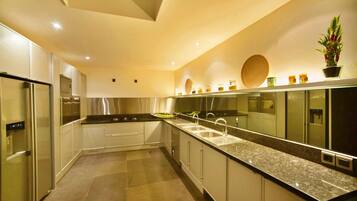 A modern kitchen with stainless steel appliances, a granite countertop, and a backsplash with decorative elements.