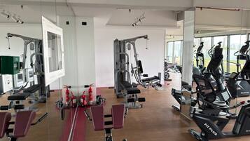 A gym with various exercise equipment, including treadmills, elliptical machines, and weight machines.
