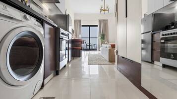 A modern kitchen with a built-in washer, oven, and stove.