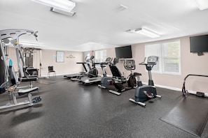A gym with various exercise equipment, including treadmills, stationary bikes, and weight machines. - Beautifully decorated 2 bed/2 bath w/ Beach Set up at Amalfi in Miramar Beach. (Miramar Beach)