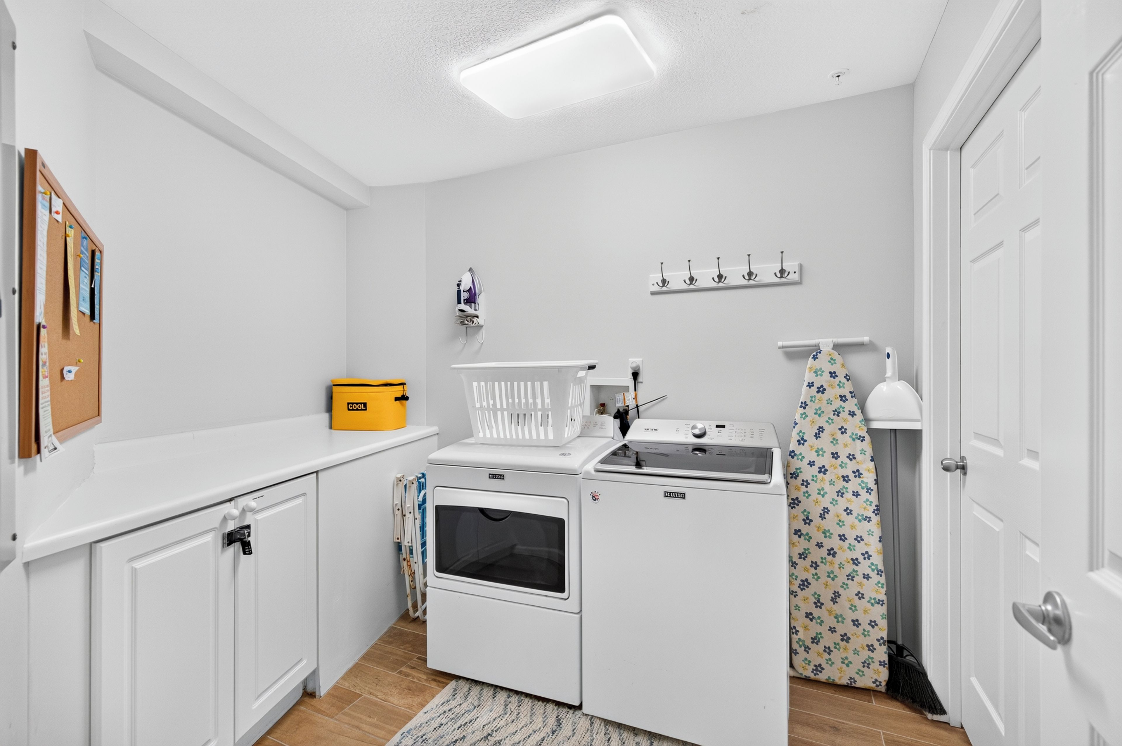 Une cuisine compacte avec des meubles blancs, un four encastré, un four à micro-ondes et un petit plan de travail.