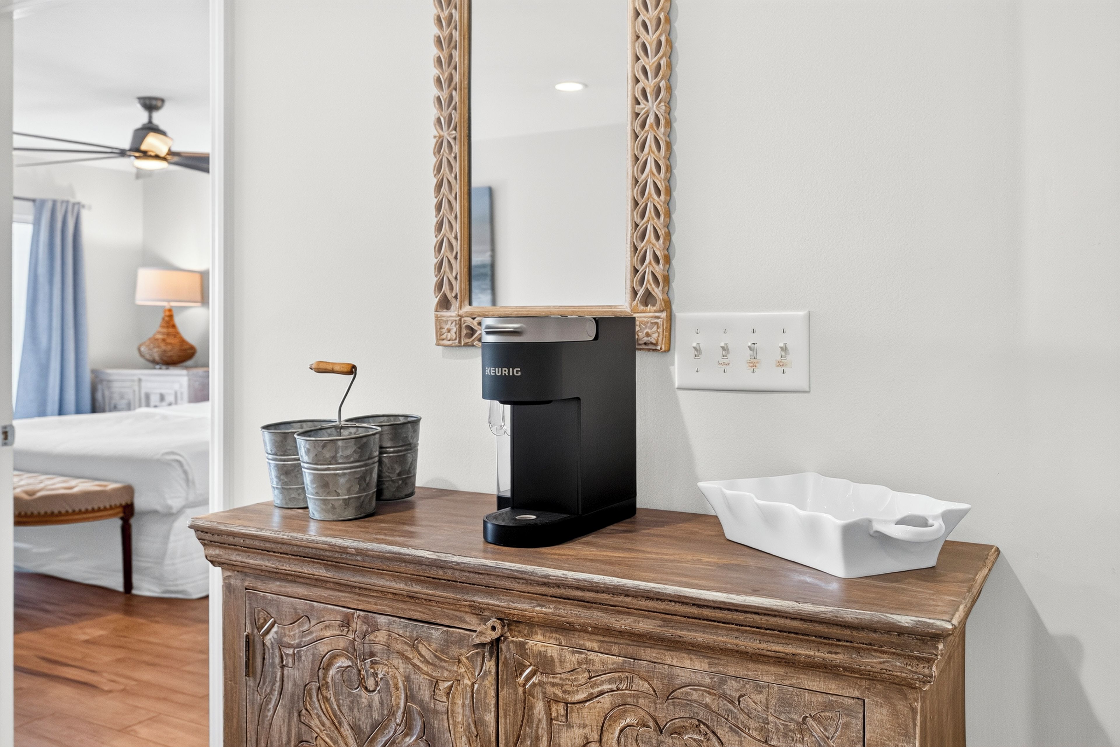A coffee machine on a wooden counter with a mirror above it.