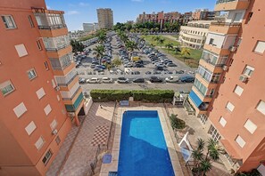 A residential area with a swimming pool, parking lot, and apartment buildings. - Costa del Sol Apartment with Balcony, Wi-Fi, Air Conditioning (Torremolinos)