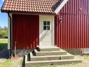 A red building with a white door and a small porch with steps leading up to it. - 6 Person Holiday Home in Gullbrandstorp (Haverdal)