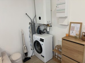 A laundry area with a washing machine, an iron, and a water heater.
