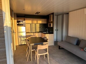 A compact living space with a kitchenette, dining area, and a sofa.
