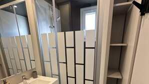 A bathroom with a white sink, a mirror, and a shower enclosure. - The Scandola Reserve (Appietto)