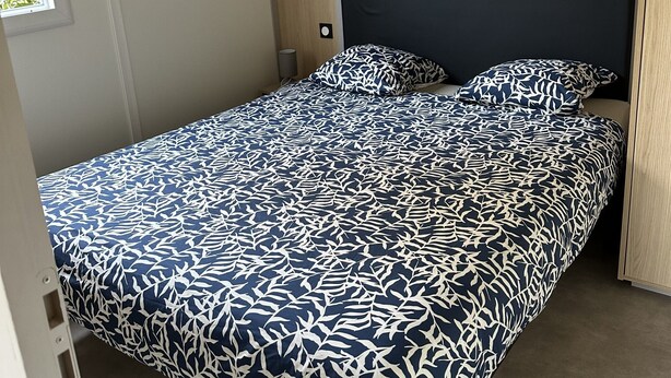 A single bed with a patterned bedspread in a room with a wooden headboard and a window. - The Lava Hills - Girolata (Appietto)