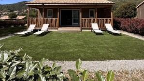 A house with a tiled roof, a front porch with two chairs, and a well-maintained lawn. - The Lavezzi Islands - 4-Bedroom Chalet (Appietto)