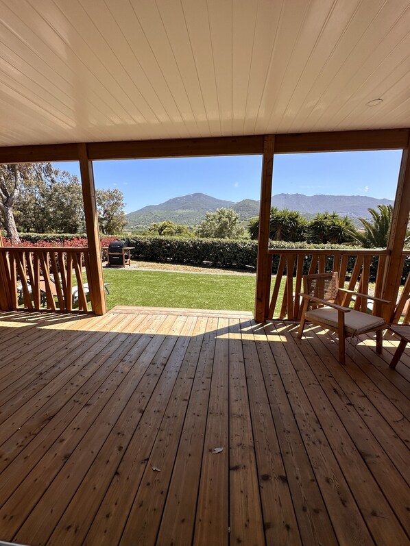 A wooden deck with a view of a mountain range.