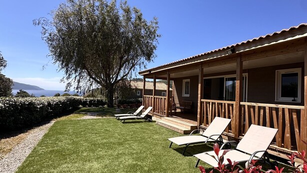 A building with a covered patio area, outdoor seating, and a view of the sea. - The Lavezzi Islands - 4-Bedroom Chalet (Appietto)