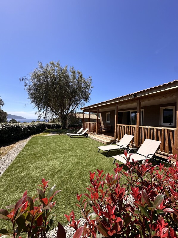 A building with a covered patio area, outdoor seating, and a view of the sea.