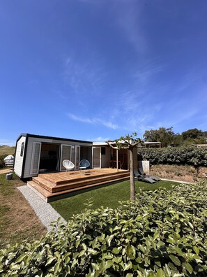A modern mobile home with a deck, outdoor seating, and a well-maintained garden. - Modern & cozy mobile homes with panoramic views (Appietto)