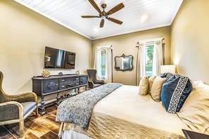 A bedroom with a bed, a dresser, a TV, a ceiling fan, and a window with curtains. - The Big Top ~ Near St. Armands ~ Pool/Spa (Sarasota)
