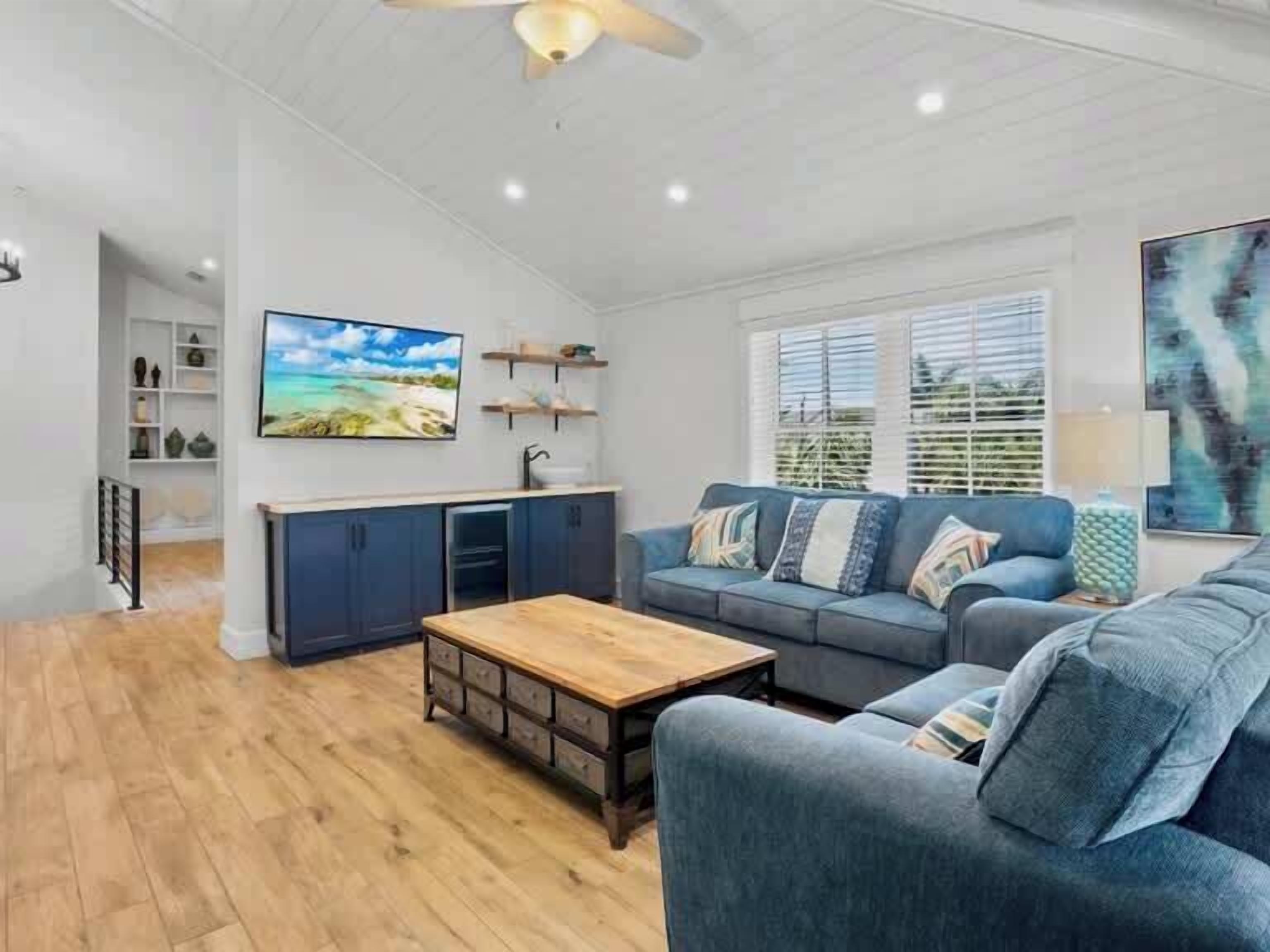 Un salon moderne avec un canapé, une table basse et un téléviseur fixé au mur.