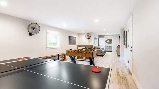 A room with a ping pong table, a foosball table, and a sofa. - The Shore House~St Armands, Lido Beach, Pool (Sarasota)