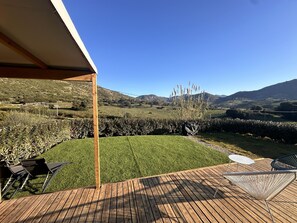 A wooden deck with outdoor furniture, a grassy yard, and a view of rolling hills. - Les Sanguinaires - Mobile Home (Appietto)