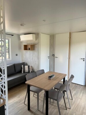 Ein modernes Interieur mit Esstisch, Stühlen, einer Couch und einem Kleiderschrank.