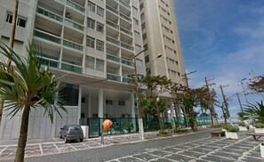 Un edificio moderno con varios pisos, un estacionamiento y algunas áreas verdes.