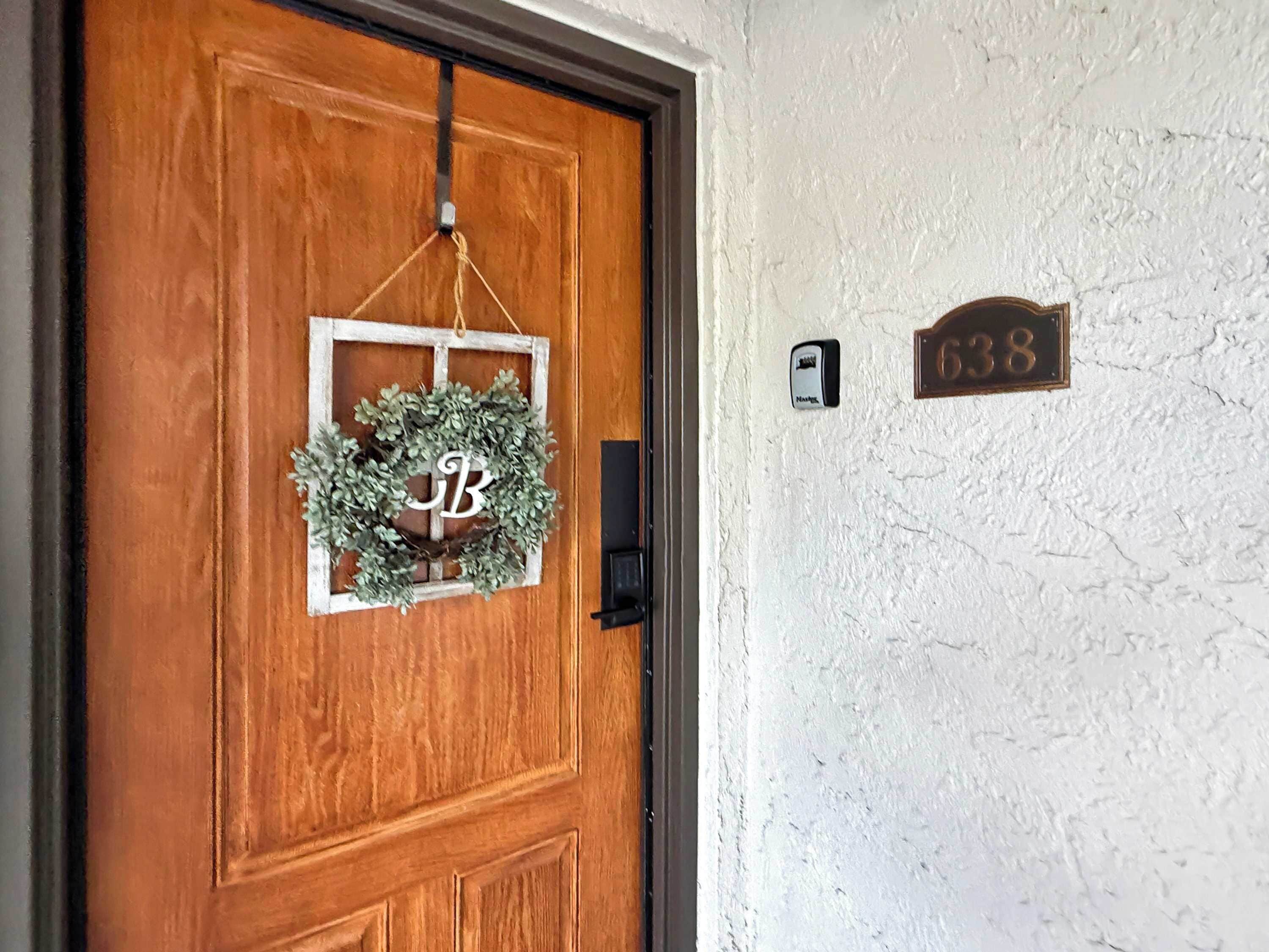 A wooden door with a wreath and a nameplate.