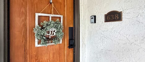 A wooden door with a wreath and a nameplate.