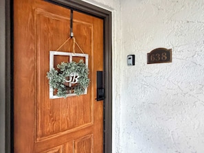 Une porte en bois ornée d’une guirlande et d’une plaque avec un nom.
