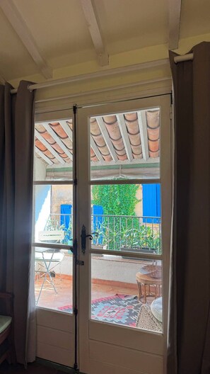 Eine Tür mit Blick auf eine Terrasse, inklusive Tisch und Stühlen.
