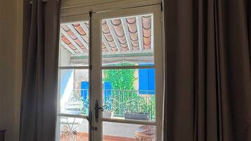 A room with a door leading to an outdoor area, a chair, and a tiled floor.