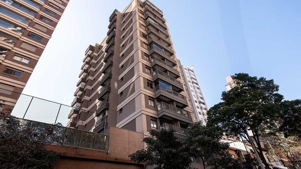 Un edificio residencial alto con varios balcones y un diseño arquitectónico moderno.