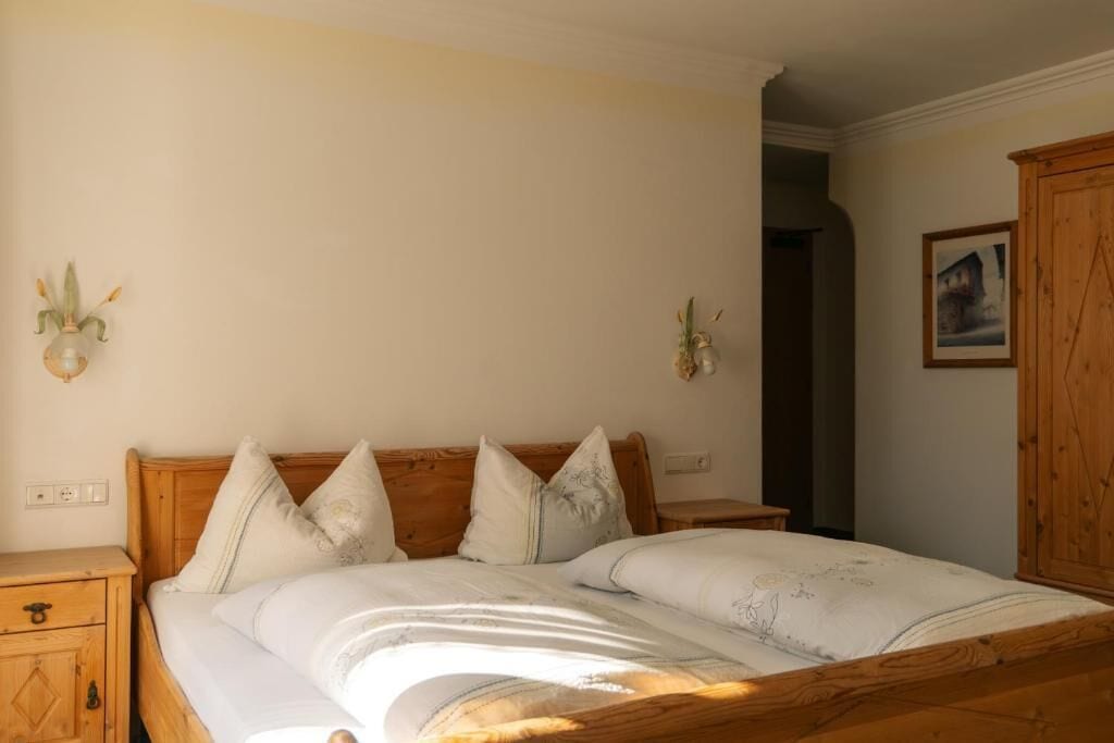 A bedroom with a wooden bed, bedside tables, and a wardrobe.
