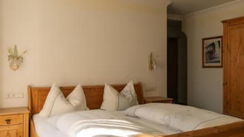 A bedroom with a wooden bed, bedside tables, and a wardrobe.