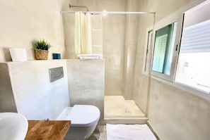 Een badkamer met toilet, wastafel en douchehoek.
