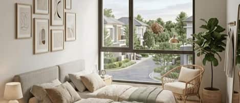 A bedroom with a large window, a bed, a chair, and a potted plant.