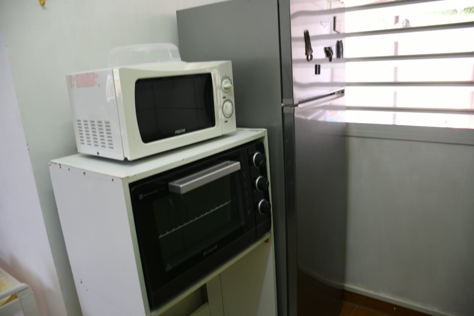 Una cocina con un microondas y un horno uno encima del otro.