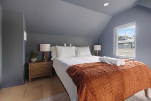 A bedroom with a bed, nightstands, a window, and a view of a building outside. - Tremendous 9-bedroom Luxury Compound - Two Pools & Two Houses (Austin)
